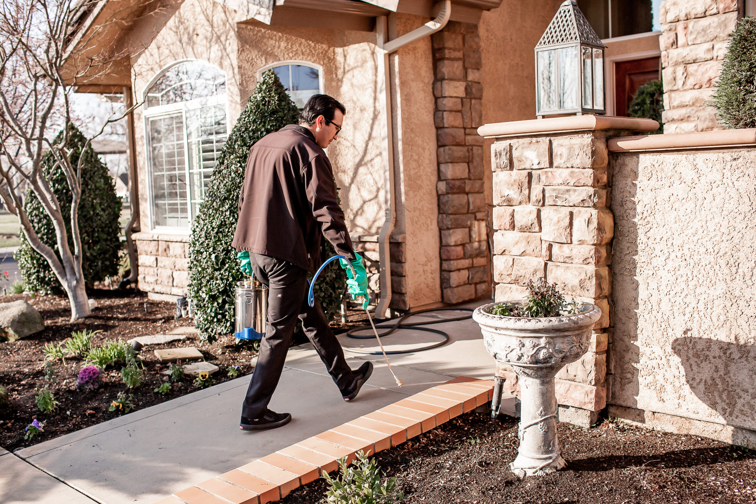 San Joaquin Pest Control Team Spraying a home entrance way for pest preventation